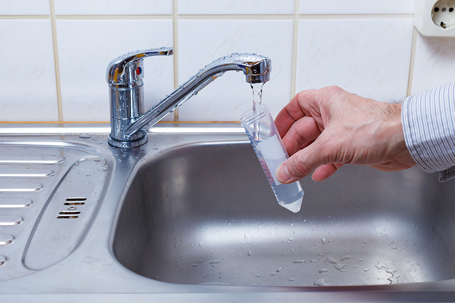 person taking a water sample